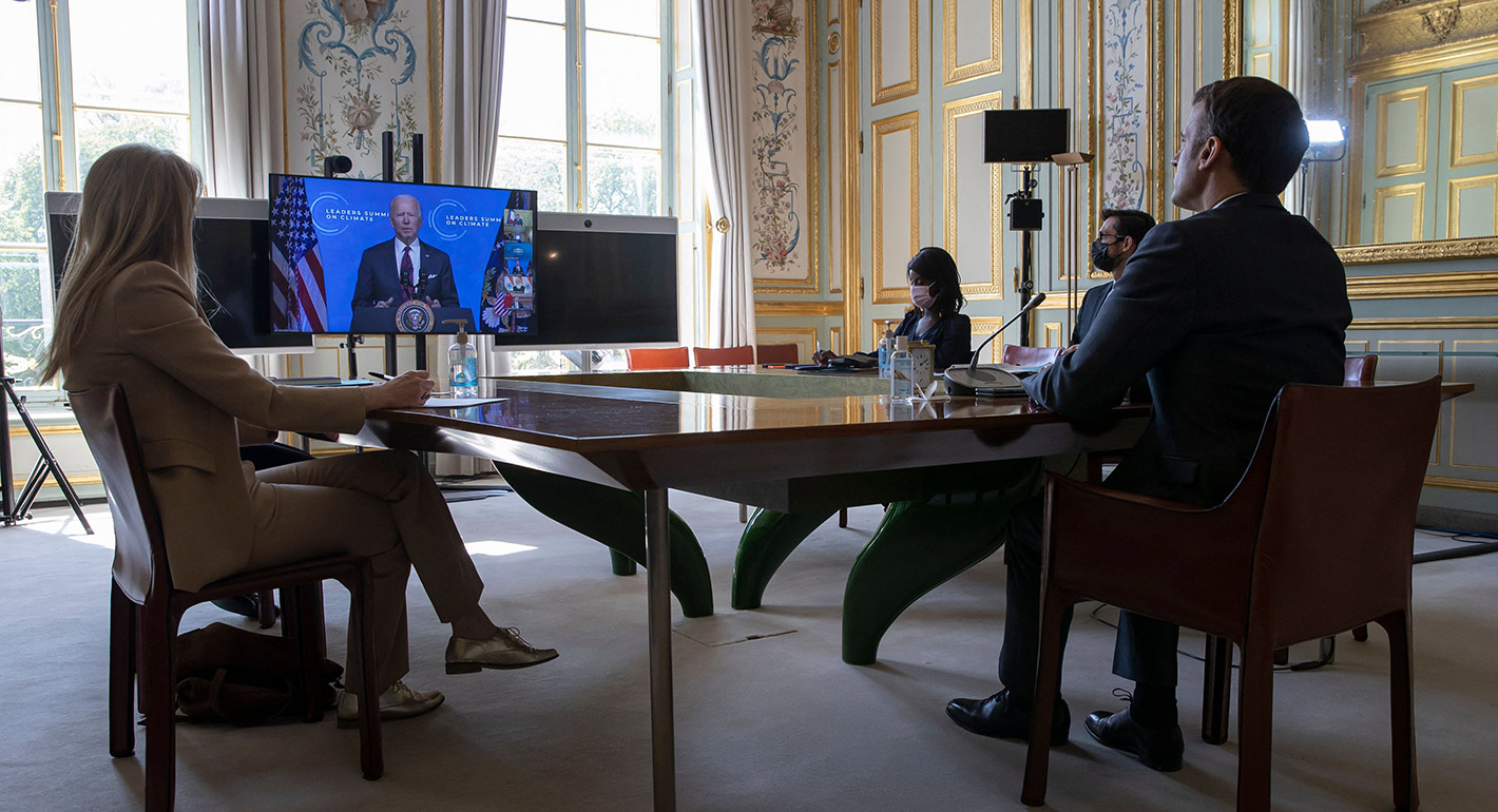 French President Macron listens to US President Biden (on screen) during a virtual summit